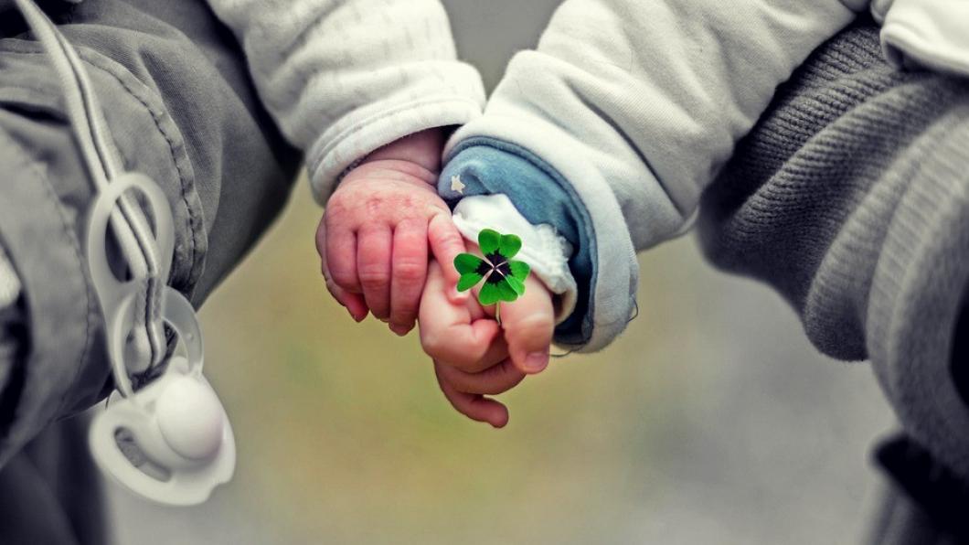 foto twee kinderhanden met een klavertje vier