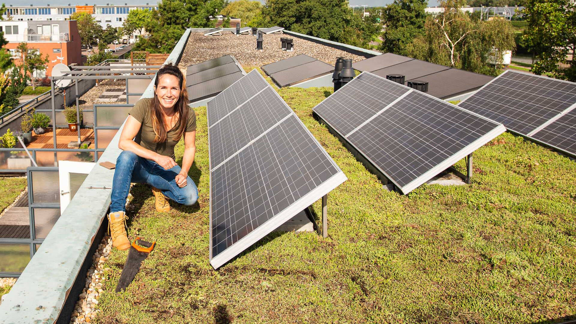 vrouw monteert zonnepanelen op een dak